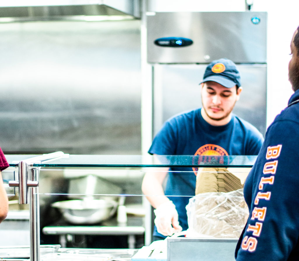 A Bullet Hole employee serves food using the new cardboard to-go containers Photo Allyson Frantz/The Gettysburgian)