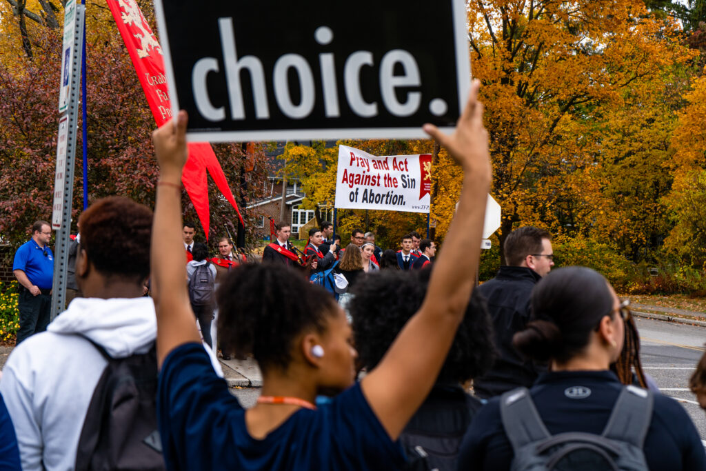 Students provide counter-protest against The American Society for the Defense of Tradition, Family, and Property (TFP) outside Servo on Tuesday, Oct. 25, 2022. One student holds a pro-choice Marty Qually sign (Photo Will Oehler/The Gettysburgian).