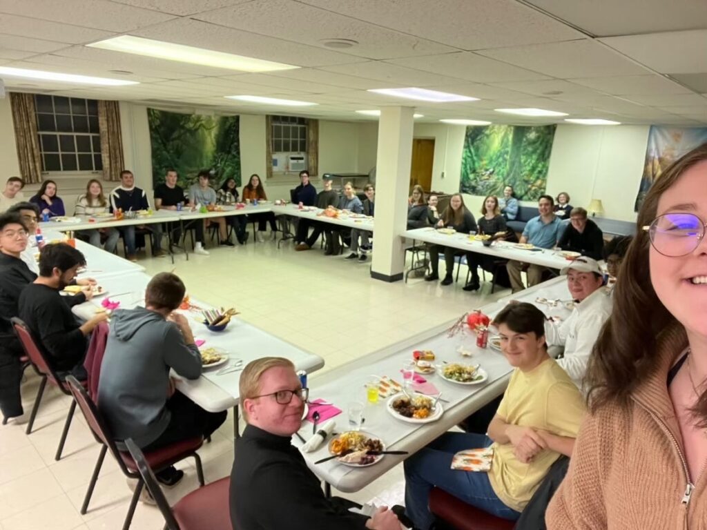 Students sit around a table at the Interfaith Thanksgiving hosted by Hillel and the Newman Association (Photo courtesy of Hannah Repole '25)