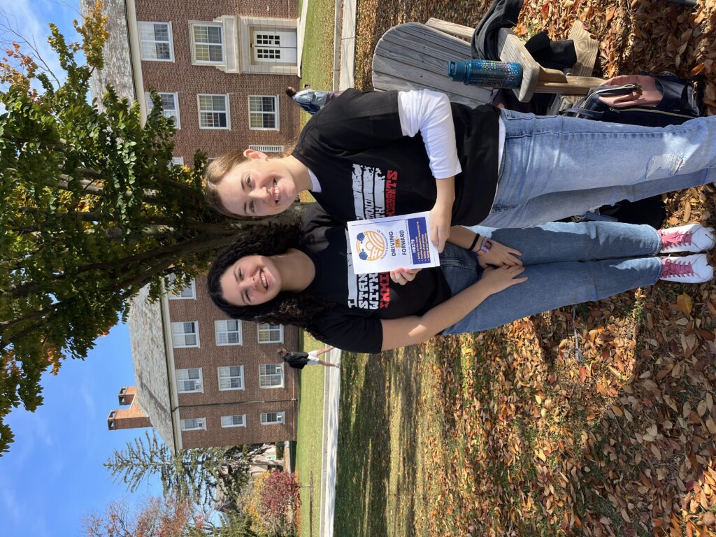 CPS Program Coordinators Rachel Farbman '25 (left) and Molly Hoffman '24 hold a sign for Driving PA Forward at the CPS and the Butterfly Coalition's Day of Action event on Nov. 2, 2022 (Photo Alli Dayton/The Gettysburgian)