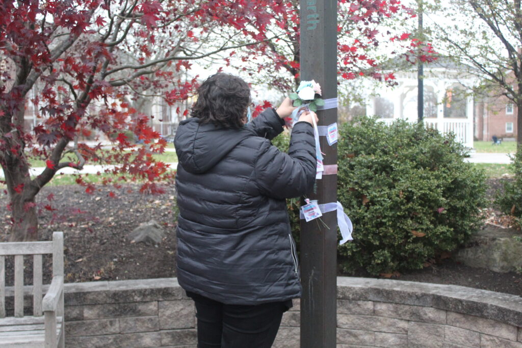 A student ties ribbon to the Peace Pole for Trans Day of Remembrance on Nov. 18, 2022 (Photo Annie Bolenbaugh/The Gettysburgian)
