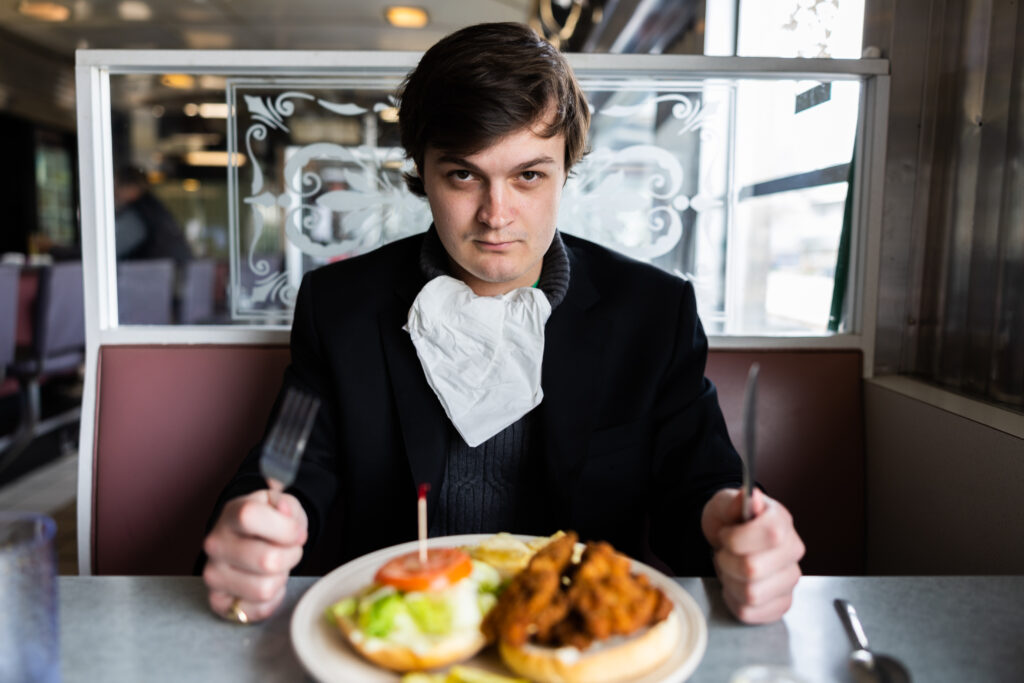 Blake Dudley '23 sits to eat Lincoln Diner's fried oyster sandwich for his review (Photo Eric Lippe/The Gettysburgian)