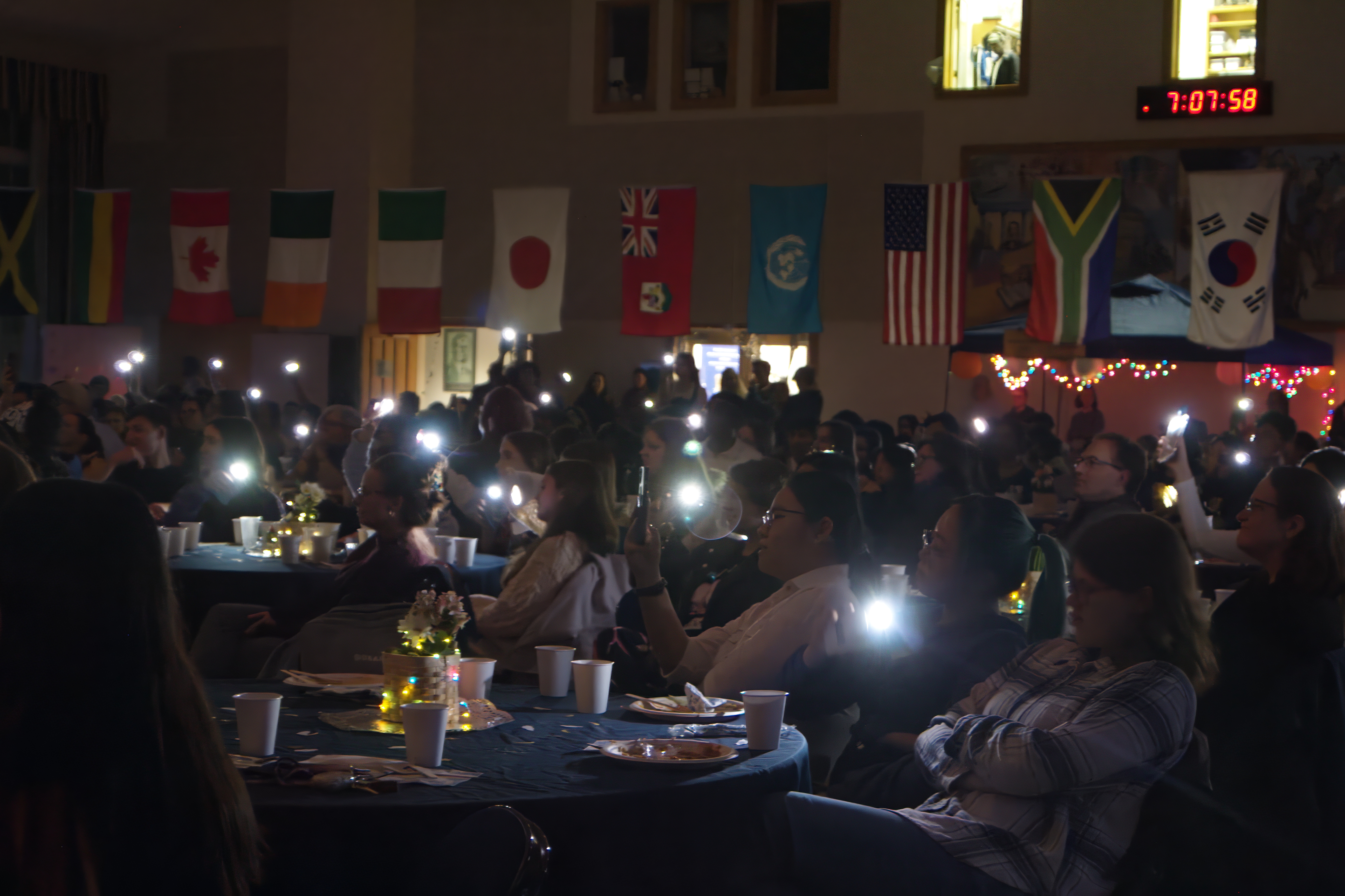 Audience members shining their cell phone lights during a performance. (Photo Abror Niyazmetov/The Gettysburgian)